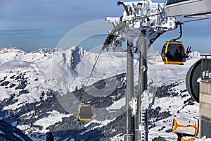 Gondola lift. Cabin of ski-lift in the ski resort in the early morning at dawn with mountain peak in the distance. Winter
