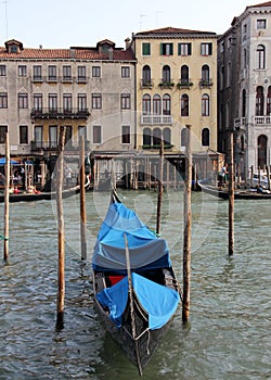 Gondola parked in the canal, old waterfront palatial houses across the canal in the background, Venice, Italy