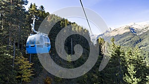 Gondola ski lift against mountain forest