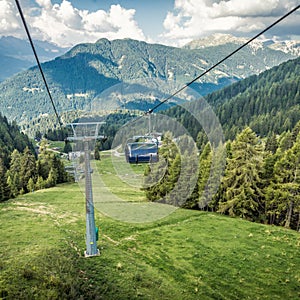 gondola ski lift in mountain ski resort, green forest