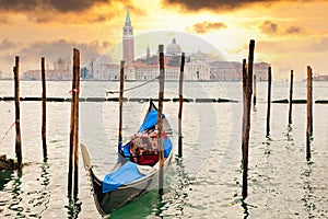 Gondola at sunset pier near in Venice, Italy