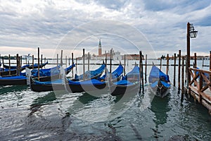 Gondolas anchored by Piazza San Marco with San Giorgio di Maggiore church in Venice