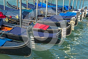 Gondolas in Grand Canal stake pier at golden sunset, Venice, Italy