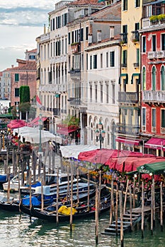 Gondolas on the Grand Canal in Venice next to old colorful palaces