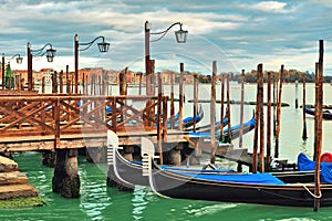 Gondolas moored in row on Grand canal in Venice.