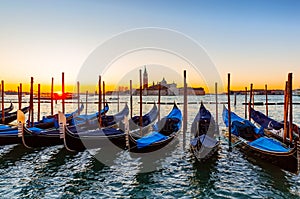 Gondolas moored by Saint Mark square against San Giorgio di Maggiore church in Venice, Italy