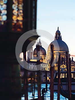 Gondolas moored by Saint Mark square with Cathedral of Santa Maria della Salute on background. Focus on Cathedral