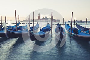 Gondolas moored by Saint Mark square with San Giorgio di Maggiore church in Venice,