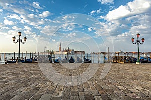 Gondolas moored by Saint Mark square with San Giorgio di Maggiore church in Venice, Italy