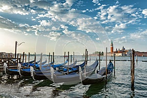 Gondolas moored by Saint Mark square with San Giorgio di Maggiore church in Venice, Italy