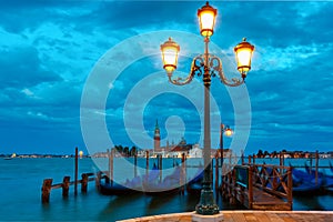 Gondolas at twilight in Venice lagoon, Italia photo