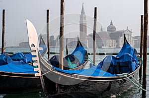 Gondolas in Venice. The gondolas are moored at the mooring posts. Venice, Italy.