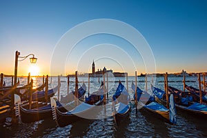 Gondolas. Venice Italy seafront with gondolas and church on background