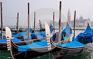 Gondolas in Venice. The gondolas are moored at the mooring posts. Venice, Italy.