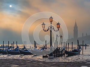 Gondolas in Venice at sunrise in morning fog. Veneto, Italy