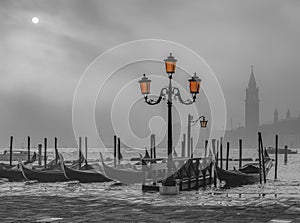 Gondolas in Venice at sunrise in morning fog. Veneto, Italy