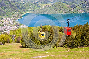 Gondolas of Zwoelferhorn Seilbahn cable way and a view of alpine town St.Gilgen and Wolfgangsee lake