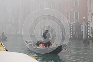 Gondolier carries tourists through the canals of Venice.