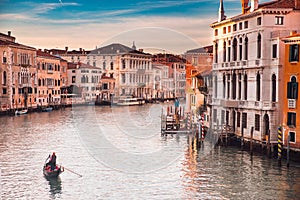 Gondolier carries tourists on gondola Grand Canal of Venice, Italy