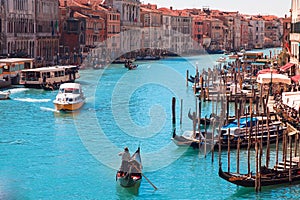 Gondolier carries tourists on gondola Grand Canal of Venice, Italy