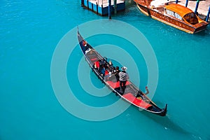 Gondolier carries tourists on gondola Grand Canal of Venice, Italy