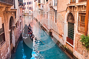 Gondolier carries tourists on gondola Grand Canal of Venice, Italy