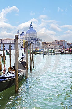 A gondolier drives a gondola with tourists on board near Santa Maria Della Salute in Venice