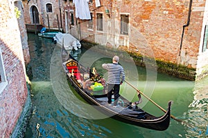 Gondolier on gondola at the views of Venice background, Italy