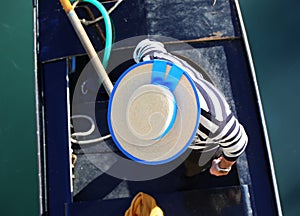 gondolier with hat rowing on gondola boat on grand canal in Venice in Italy