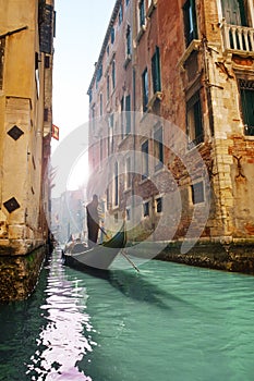 Gondolier rowing gondola in canal