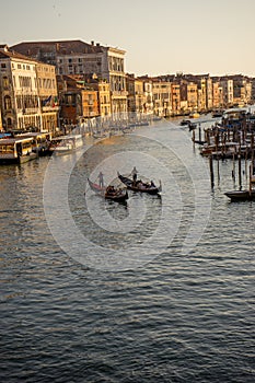 Gondolier taking tourists on a Gondola ride along the grand canal near Rialto Hotel in Venice, Italy