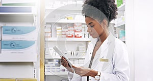 Gone are the days of piles of files. an attractive young pharmacist looking at a digital tablet in a chemist.