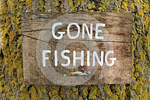 A Gone Fishing Sign On A Tree