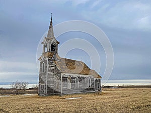 A long time abandoned church still sitting quietly on the quiet prairie