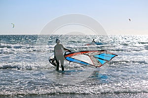 Gone surfing - Girl going windsurfing at the  Atlantic ocean