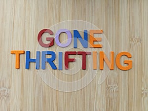 Gone thrifting sign on a wood background photo