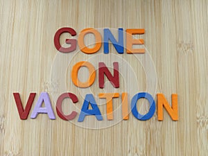 Gone on vacation sign on a wood background