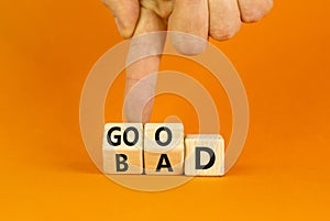 Good or bad symbol. Turned wooden cubes and changed the word bad to good. Beautiful orange table, orange background, copy space.