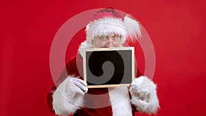 Good Christmas sales Holiday Low Prices for Shopping. Portrait Beard Santa Claus in Red Suit Looks Into Camera and Peeks