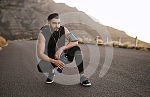 Good days start with a good workout. Shot of a sporty young man drinking water while exercising outdoors.