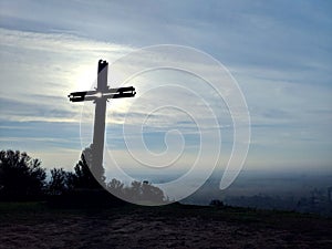 Good Friday concept: Silhouette cross of Jesus Christ on meadow sunrise sky