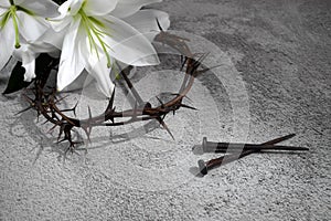 Good Friday, Passion of Jesus Christ. Crown of thorns, nails and white lily on grey background. Christian Easter holiday