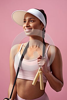 Good health inspires happiness. an attractive and sporty young woman posing with a skipping rope in studio against a