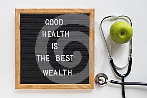 good health message board with green apple stethoscope white background