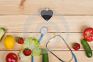 Good healthy and diet concept - Blackboard in shape of heart, stethoscope and vegetables, fruits and berries