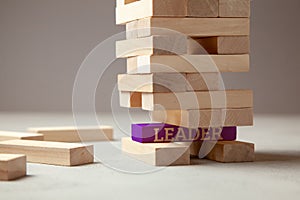 Good leader is building successful team and company in business. Tower of wooden blocks with the inscription leader