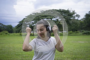 Good-looking asian young woman with no makeup having fun with favorite music outdoor