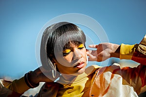 Good-looking bronzed model having bangs and yellow eye make up