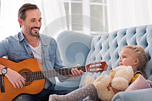 Good looking caring father singing for his daughter