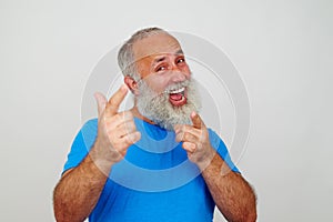 Good-looking elderly man energetically pointing at the camera